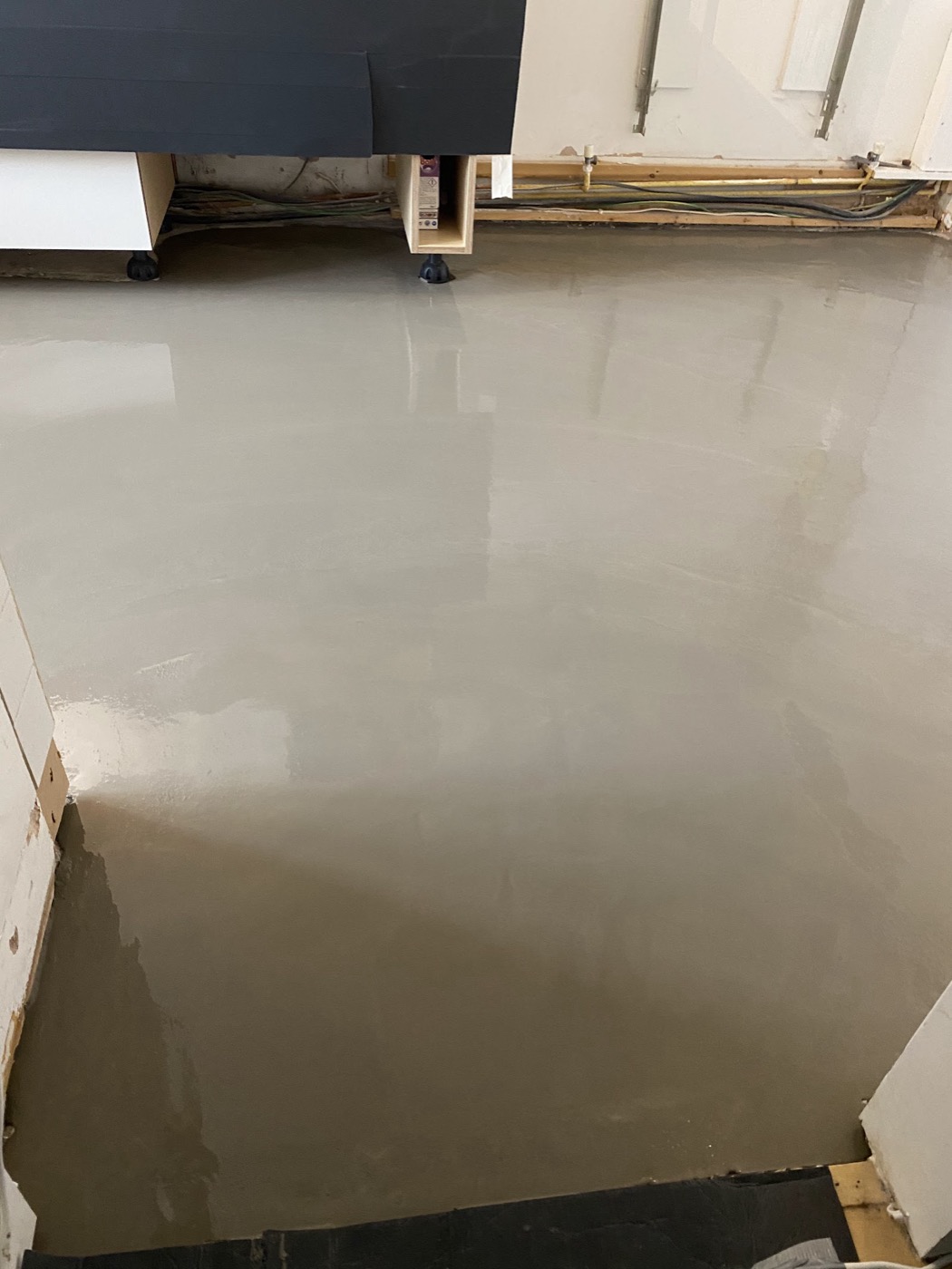 Self-levelling screed poured and smoothed over a prepared subfloor — the unseen groundwork before the wood goes down.